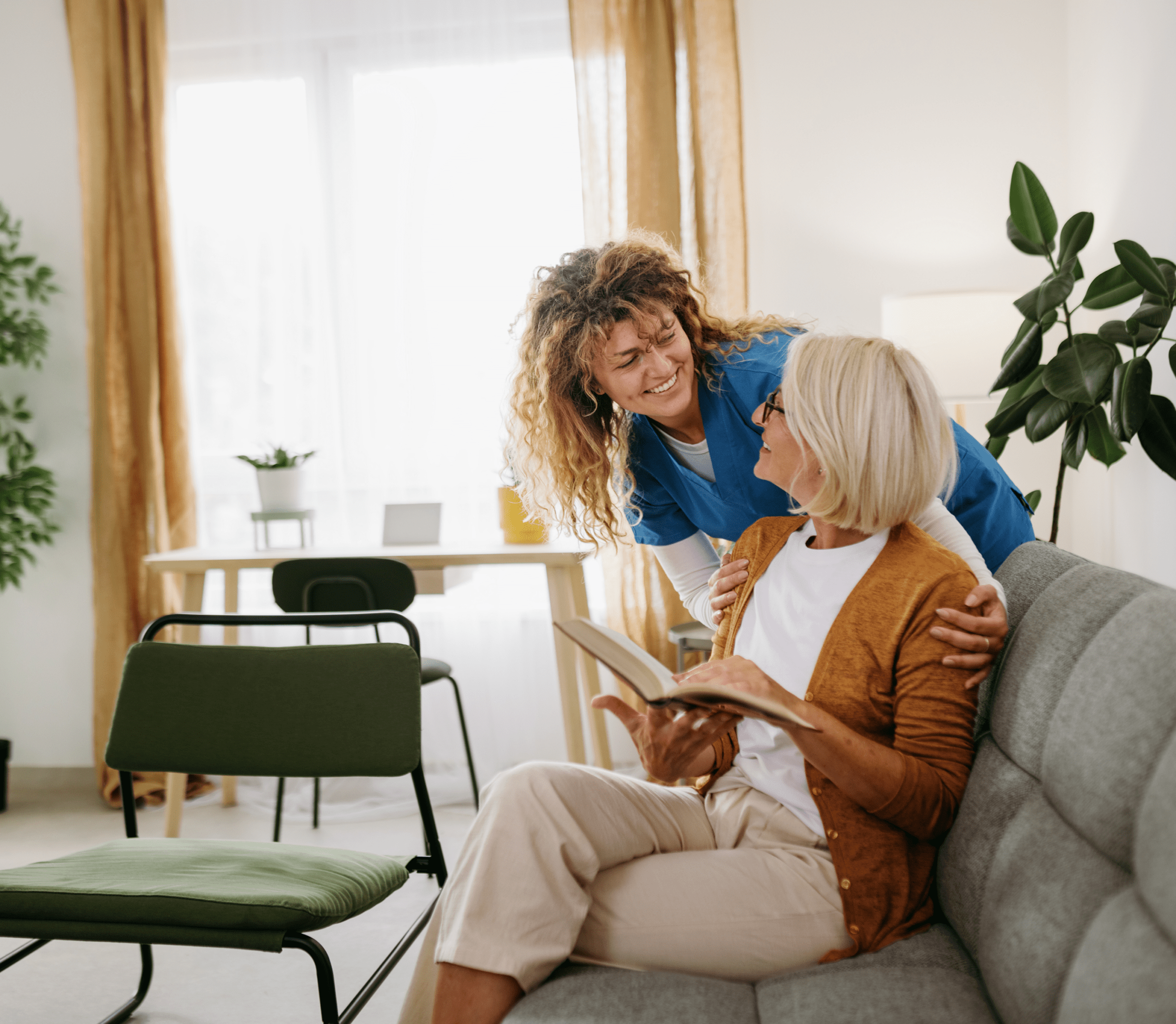 Nurse comforting elderly woman on couch