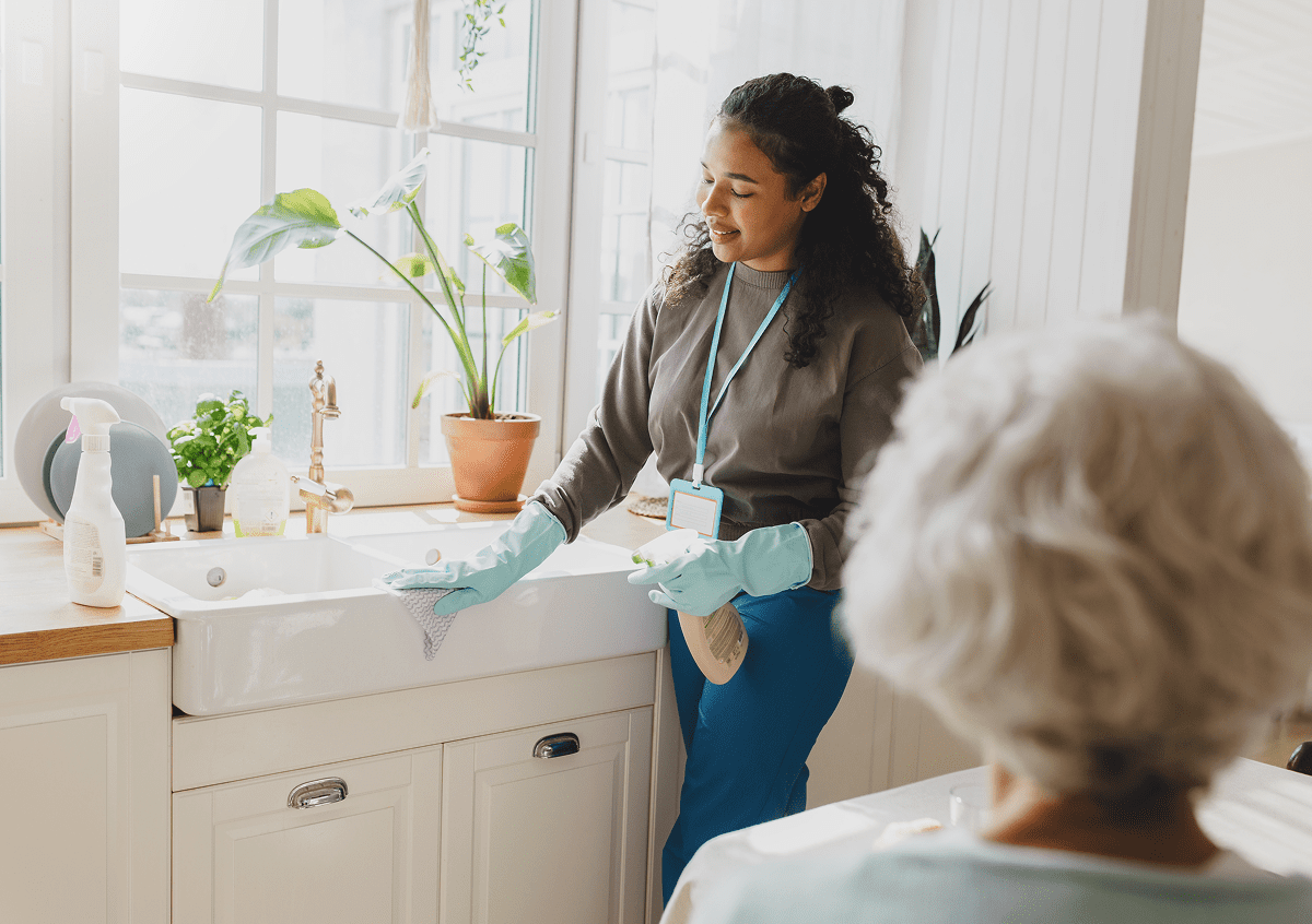 Woman cleaning kitchen sink with gloves