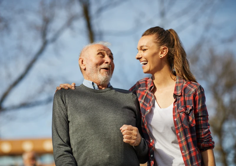 Elderly man and young woman laughing together