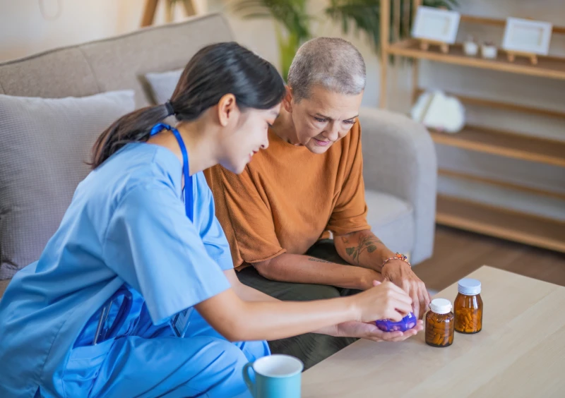 Nurse assisting elderly woman with medication